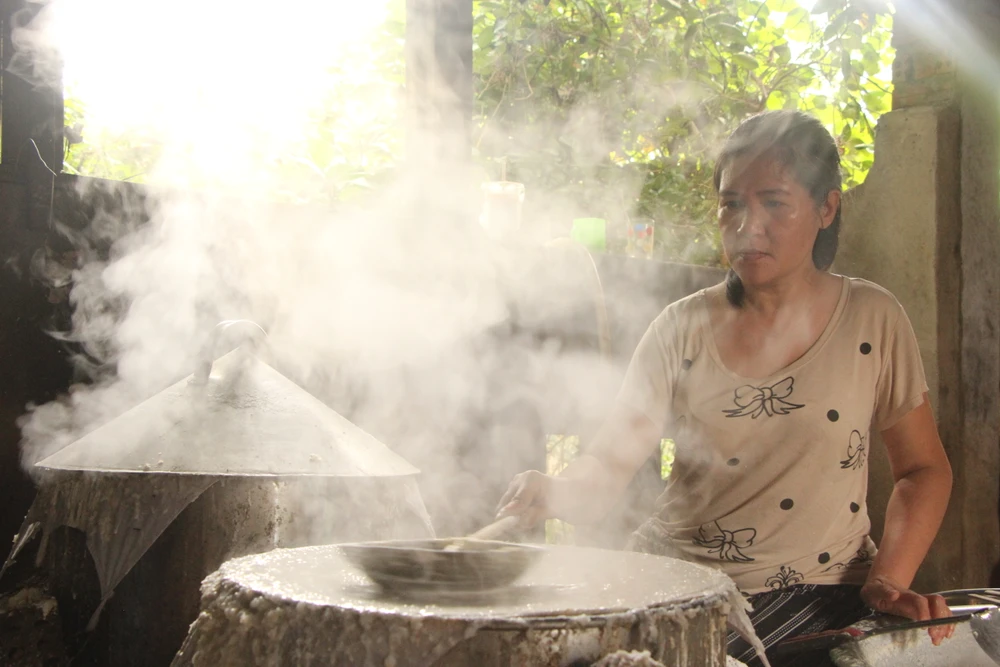 Chị Nguyễn Đặng Thái Hòa con gái cụ Phong đang thực hiện công đoạn tráng bánh. Ảnh: NGÔ QUANG.