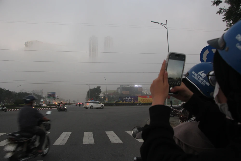 Người dân lưu thông trên đường dừng lại chụp ảnh hiện tượng kỳ lạ này. Ảnh: NGÔ QUANG Người dân lưu thông trên đường dừng lại chụp ảnh hiện tượng kỳ lạ này. Ảnh: NGÔ QUANG