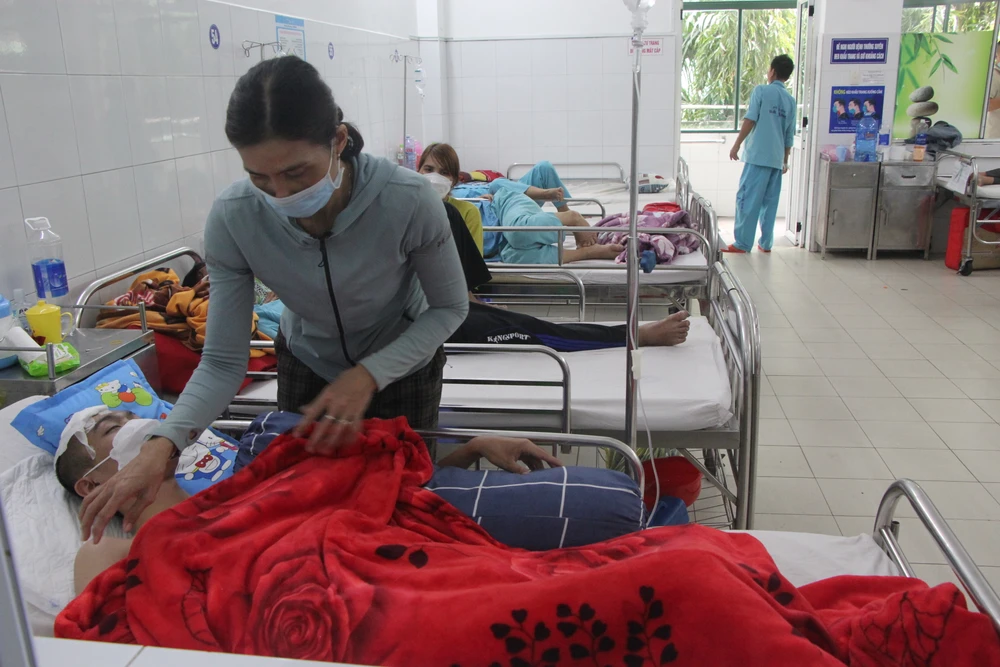 Chị K đang chăm sóc cho con trai.Ảnh: NGÔ QUANG