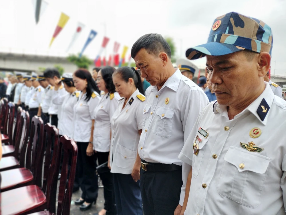 Đồng đội cúi đầu tưởng niệm 64 liệt sĩ đã anh dũng hi sinh ở đảo Gạc Ma.Ảnh: NT