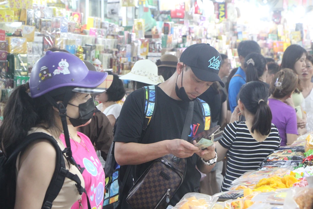 Du khách Hàn Quốc mua sắm tại chợ Hàn.Ảnh: NGÔ QUANG