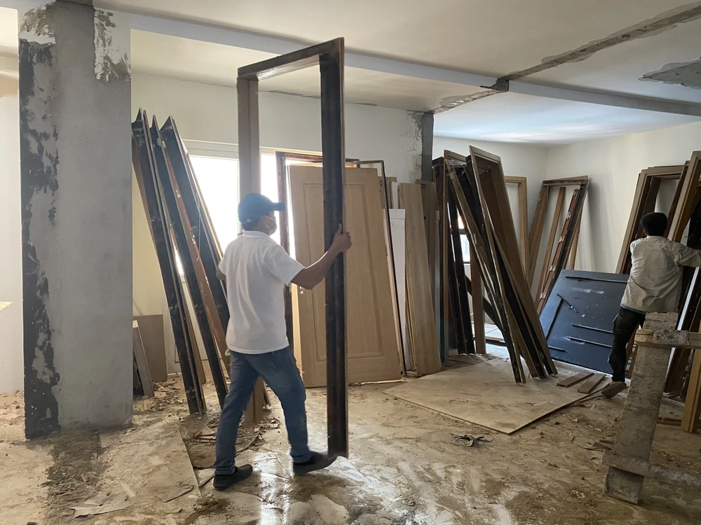 Các công nhân đang vận chuyển các vật liệu gỗ ra bãi tập kết.Ảnh: NGÔ QUANG