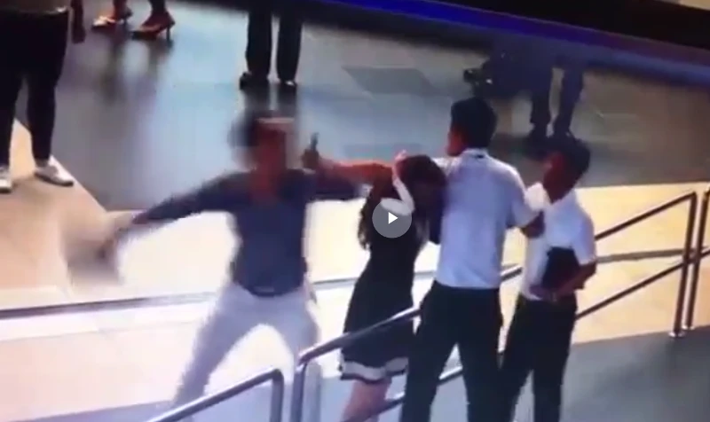 Hành khách dùng máy tính bảng đánh vào đầu nữ nhân viên. Ảnh cắt từ clip sân bay Nội Bài