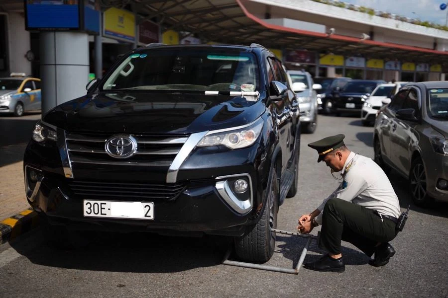 Xe ô tô vi phạm bị lực lượng chức năng khóa bánh. Ảnh: B.HÀ