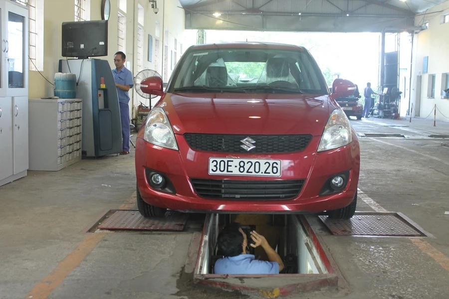 Nhân viên đăng kiểm thực hiện các bước kiểm định xe. Ảnh: V.LONG