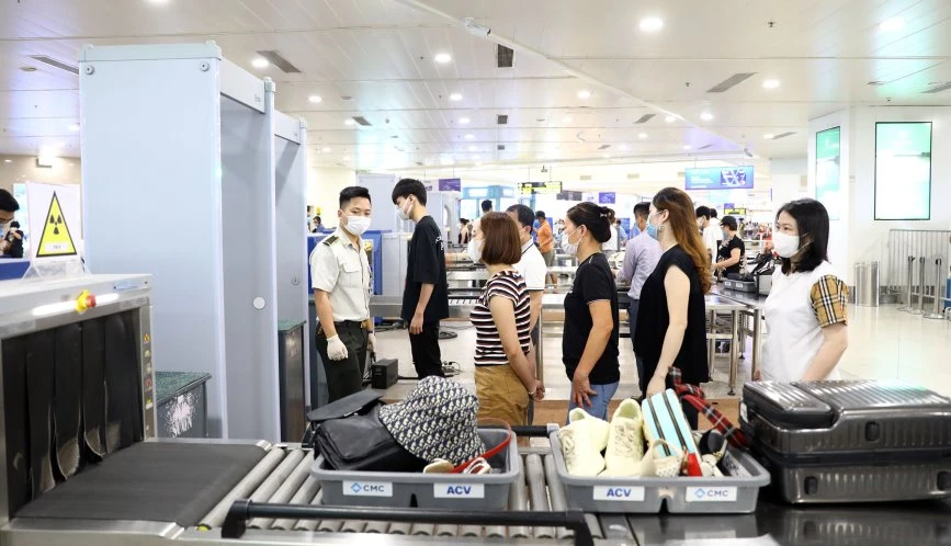 Nhân viên an ninh Nội Bài kiểm tra hành lý của khách. Ảnh: N.HÀ