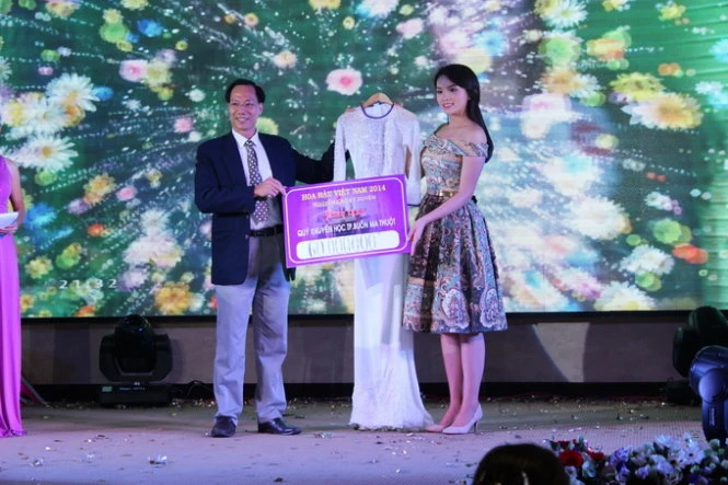 Ông Lê Đình Thành trao tượng trưng số tiền 60 triệu đồng cho hoa hậu Nguyễn Cao Kỳ Duyên để nhận chiếc áo dài -Ảnh: Hà Bình/TTO