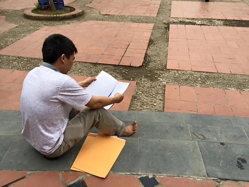 Phụ huynh ngồi ngâm cứu hồ sơ tuyển sinh lớp 6