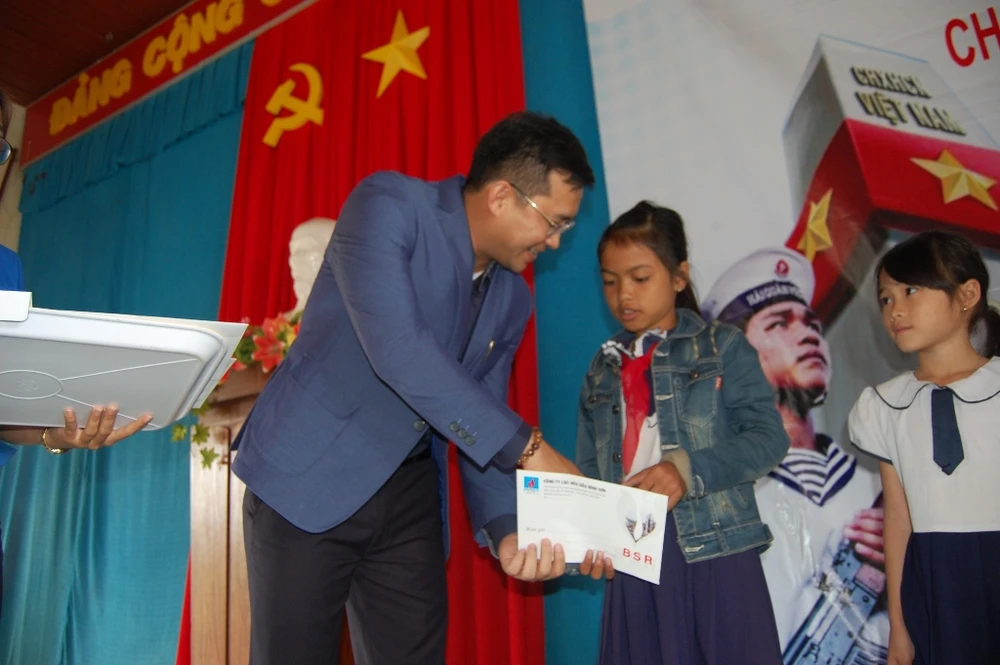 Ông Phạm Tuấn Anh, Chánh văn phòng Công ty lọc hóa dầu Bình Sơn, đại diện nhà tài trợ, trao học bổng cho các em