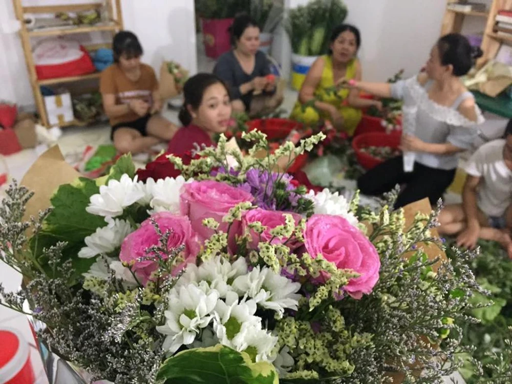 Các bạn trẻ miệt mài gói hoa để bán trong dịp 8-3 với mong muốn tậu cho em Trâm một con bò 