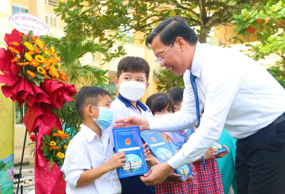 Chủ tịch UBND TP.HCM Phan Văn Mãi trao quà cho HS khó khăn. Ảnh: THẢO PHƯƠNG