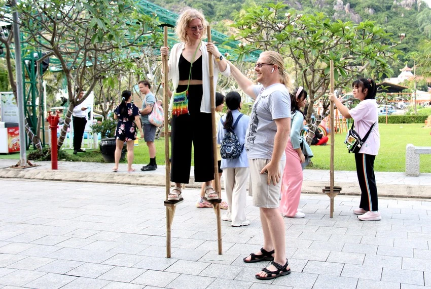 Du khách nước ngoài trải nghiệm đi cà kheo