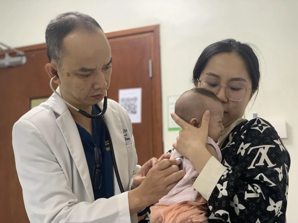 BS Nguyễn Kinh Bang đang thăm khám để xem xét mổ tim ít xâm lấn cho bé gái.