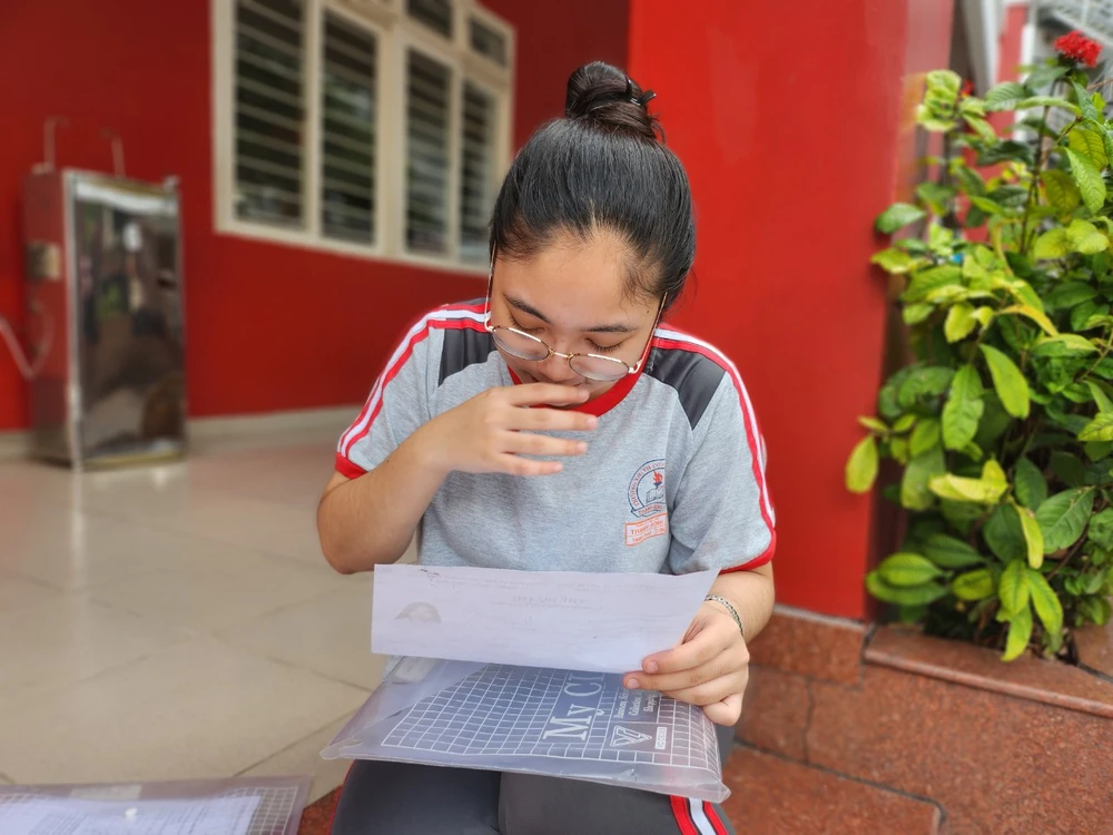 Thanh Thảo xem lại giấy tờ trước khi vào phòng thi. Ảnh: Nguyễn Quyên