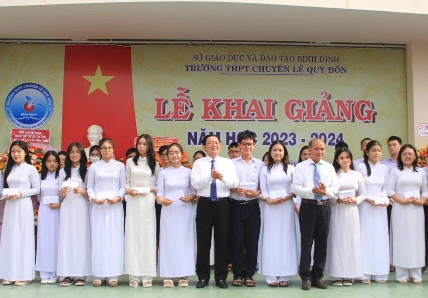 Nhiều học sinh vượt khó học giỏi được tặng quà trong lễ khai giảng. Ảnh QN