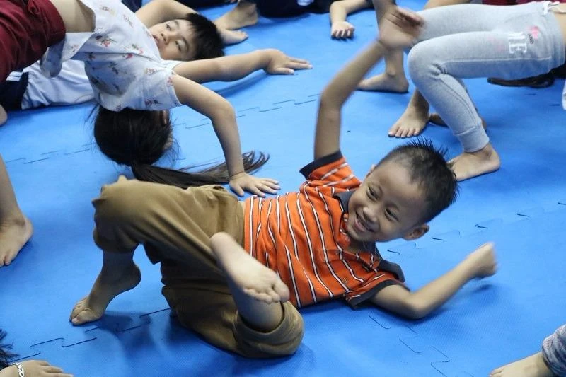 Bé trai hào hứng luyện tập theo lời thầy cô.