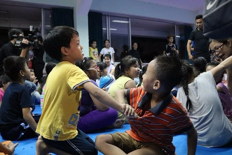 Hai bạn nhỏ thực hành theo lời cô dạy.