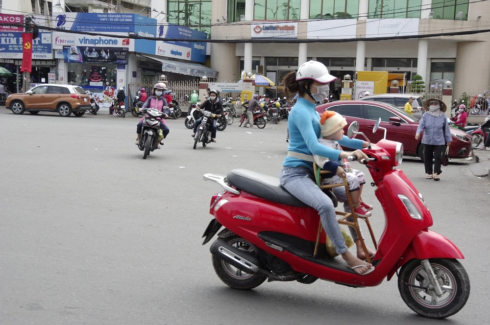 Em bé được mẹ đội thêm mũ len, áo ấm khi đi ra đường.