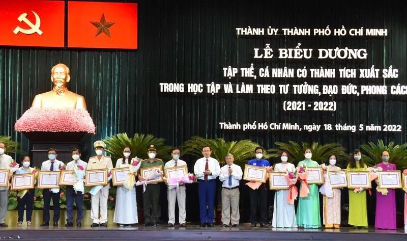 Bí thư Nguyễn Văn Nên trao bằng khen của UBND TP cho tập thể, cá nhân trong lễ biểu dương. Ảnh: TẤN THẠNH