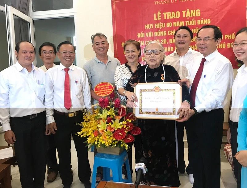 Bí thư Nguyễn Văn Nên chụp ảnh lưu niệm cùng gia đình bà Lê Thị Hồng Phúc. Ảnh: THANH TUYỀN