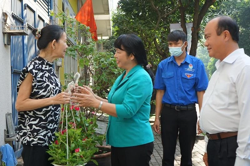 Chủ tịch Ủy ban MTTQ Việt Nam TP.HCM Trần Kim Yến đến từng nhà dân tặng hoa kiểng. Ảnh: MTTQ TP.HCM