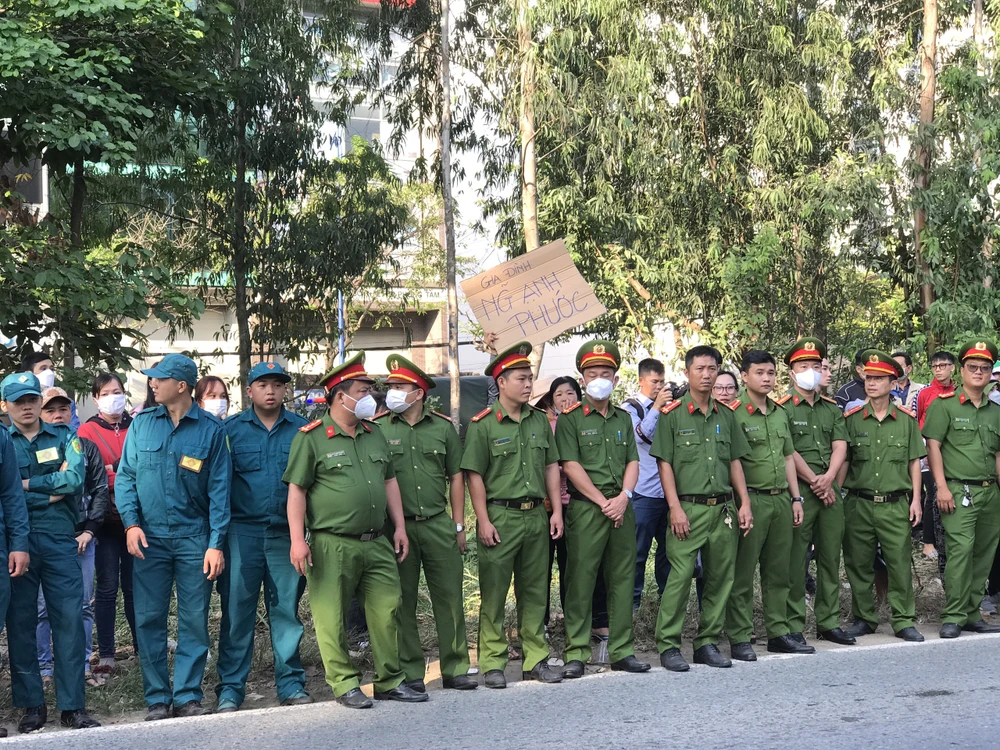 Gia đình của các tân binh giơ tấm bảng để con có thể nhìn thấy người thân trước khi lên đường nhập ngũ. Ảnh: THANH TUYỀN