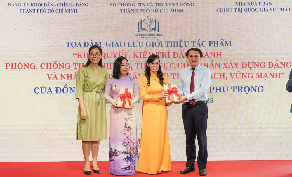 Giám đốc Sở TT&amp;TT Lâm Đình Thắng và TS Nguyễn Thị Quỳnh Nga tặng sách của Tổng Bí thư cho đoàn khối Dân- Chính- Đảng TP.HCM. Ảnh: T.T