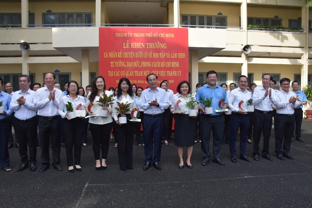 Bí thư Thành ủy TP.HCM Nguyễn Văn Nên cùng các lãnh đạo Thành ủy khen thưởng các cá nhân xuất sắc tham gia kể chuyện dưới cờ về học tập theo gương Bác. Ảnh: N.N