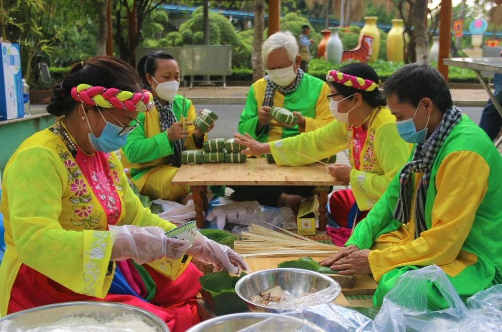 Ông Trần Quang Hóa (bìa phải) cùng đồng đội tham gia gói bánh. Ảnh: THẢO PHƯƠNG