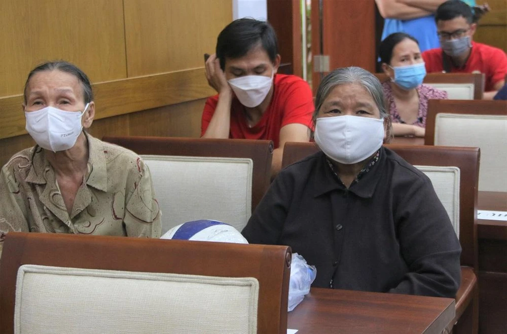 Bà Nguyễn Thị Kim Anh (áo đen) vui mừng khi cháu được tặng xe đạp. Ảnh: THẢO PHƯƠNG