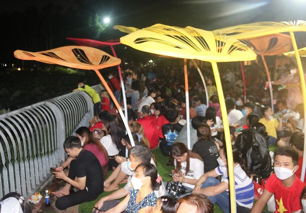 Khu vực xung quanh bến thuyền công viên đông kín người chọn sẵn vị trí có thể xem pháo hoa một cách gần nhất, đẹp nhất. Ảnh: THẢO PHƯƠNG
