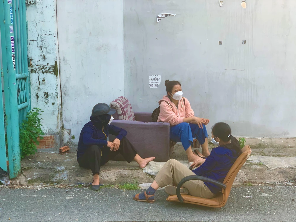 Ở một góc đầu con hẻm cạnh điểm thi THPT Trần Quang Khải (quận 11), các phụ huynh dù không quen biết nhau từ trước nhưng vẫn ngồi trò chuyện vui vẻ.