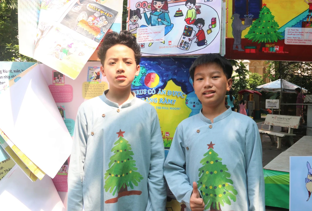 Lê Sinh Hùng (bìa phải) cùng anh họ Khôi Nguyên vẽ hình minh họa cho truyện Chiếc bóng mùa đông. Ảnh: THẢO PHƯƠNG