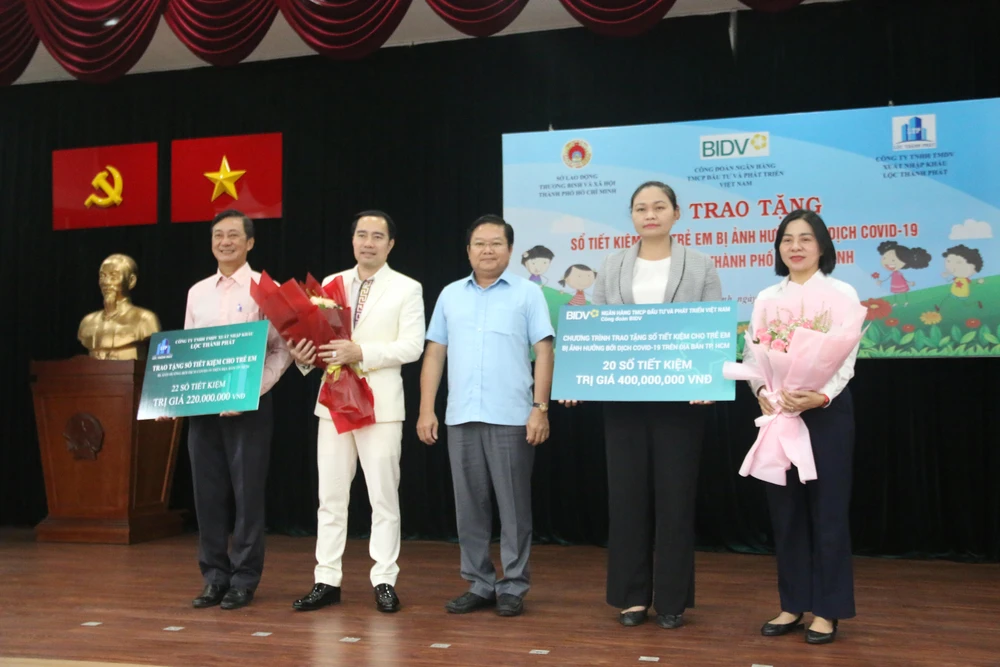 Đại diện Sở LĐTB-XH tặng hoa cảm ơn hai đơn vị tài trợ. Ảnh: THẢO PHƯƠNG