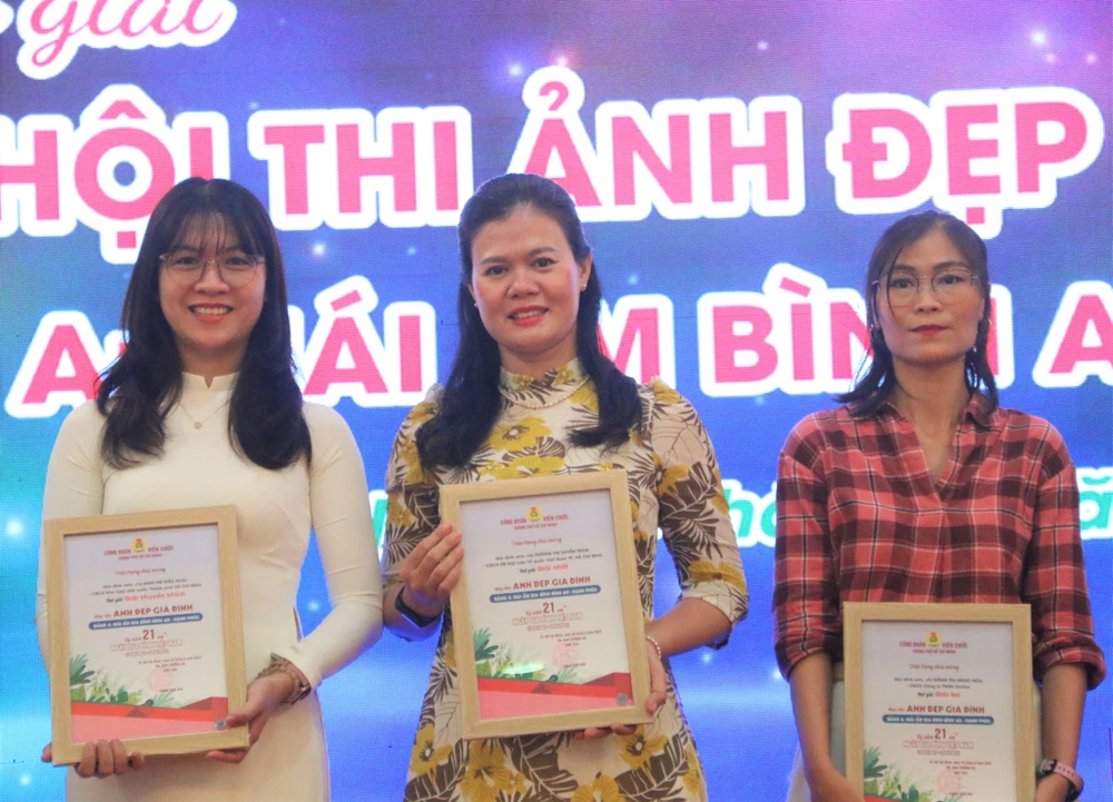 Chị Trâm (giữa) bất ngờ và xúc động khi biết được bức ảnh gia đình mình đạt giải nhất. Ảnh: THẢO PHƯƠNG