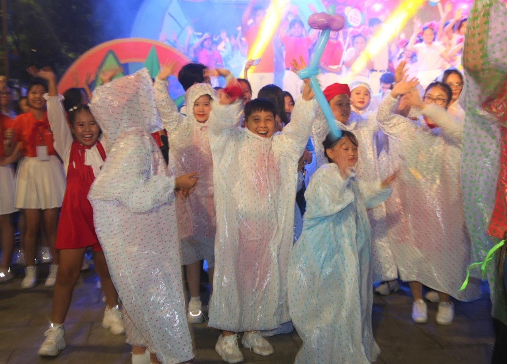 Thiếu nhi đội mưa "quẩy" tưng bừng phút cuối lễ khai mạc. Ảnh: THẢO PHƯƠNG