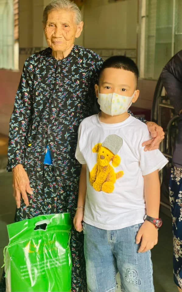 Bà Trần Thị Hơn rất vui khi nhận được bao gạo từ cậu bé 6 tuổi này. Ảnh: NVCC