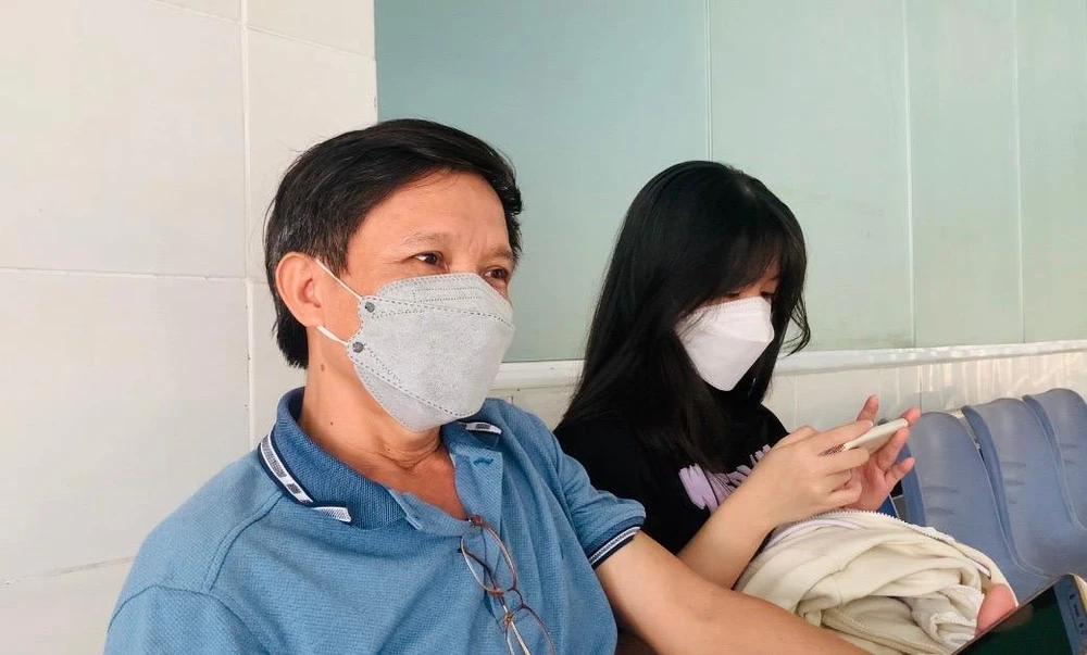 Anh Nguyễn Xuân Biên cùng con gái vừa tiêm vaccine xong. Ảnh: THẢO PHƯƠNG