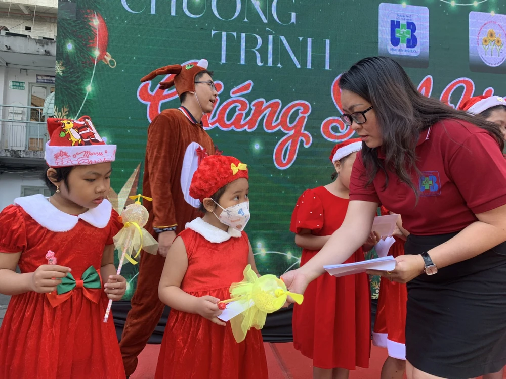 Bà Nguyễn Hồng Diễm, Trưởng phòng Công tác xã hội tặng quà cho bệnh nhi. Ảnh: THẢO PHƯƠNG