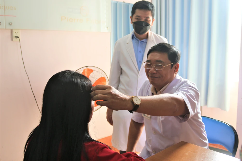 PGS-TS-BS Phạm Trịnh Quốc Khanh tư vấn cho khách hàng muốn xăm chân mày. Ảnh: THẢO PHƯƠNG