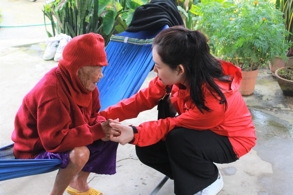 Đại diện BTC thăm hỏi và tặng lì xì cho cụ già. Ảnh: BTC