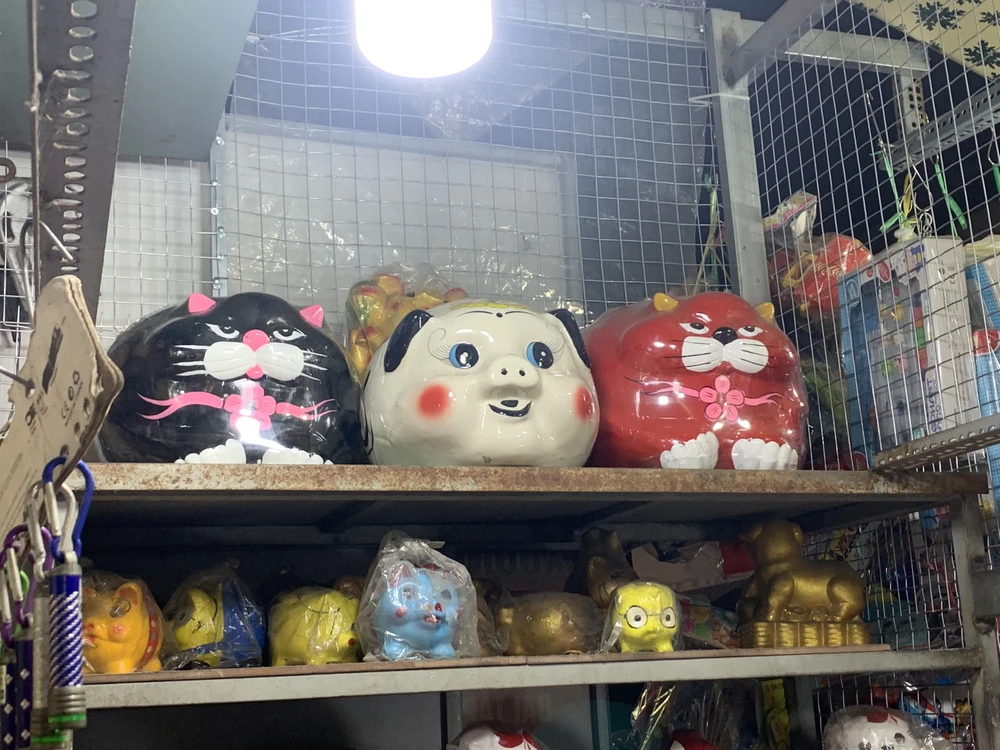 Vài năm gần đây chị Nga bán heo đất đắt hàng hơn nhiều so với 10 năm về trước. Từ 30 Tết, chị Nga đã nhập về gần 1.000 con heo. Những con heo đất đa dạng kiểu mẫu, màu sắc, được làm từ thạch cao, đất hoặc sứ. Giá mỗi con trung bình dao động từ 20 đến 100 nghìn. Tuy nhiên vẫn có vài con được người bán gọi là “vía xịn”, đắt nhất là 1,2 triệu đồng (con heo sứ trắng ở giữa). Ảnh: THẢO PHƯƠNG