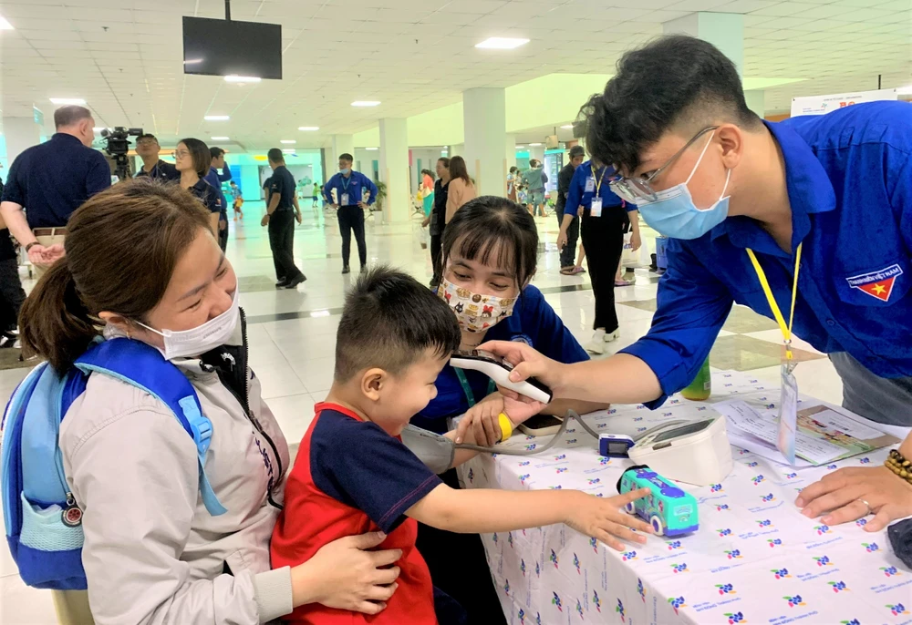 Bé trai được đo nhiệt độ, huyết áp. Ảnh: THẢO PHƯƠNG