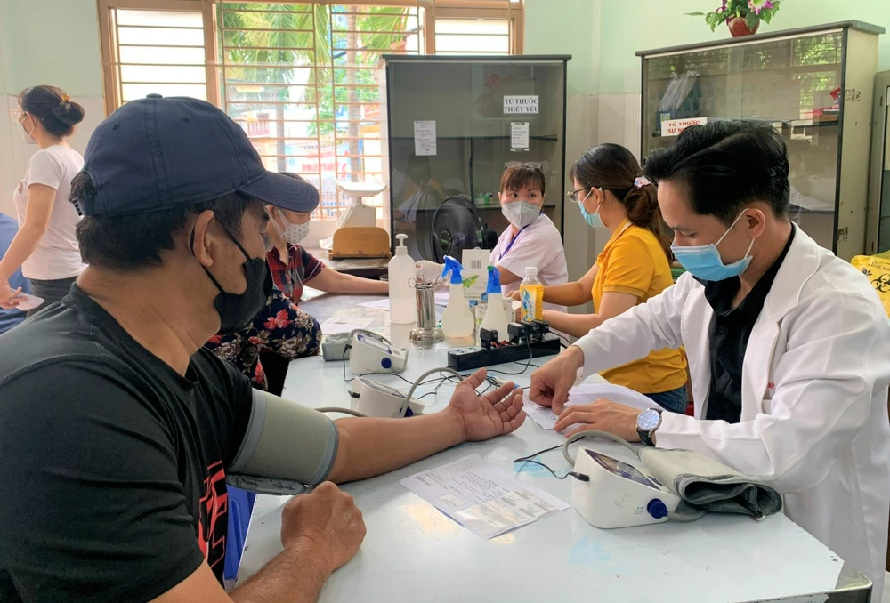 Nhân viên y tế khám bệnh cho người dân tại Trạm y tế phường 11, quận 6. Ảnh: THẢO PHƯƠNG