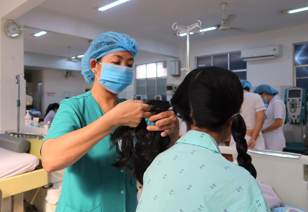 Hộ lý Trang Thị Kim Loan chăm sóc bệnh nhân. Ảnh: THẢO PHƯƠNG