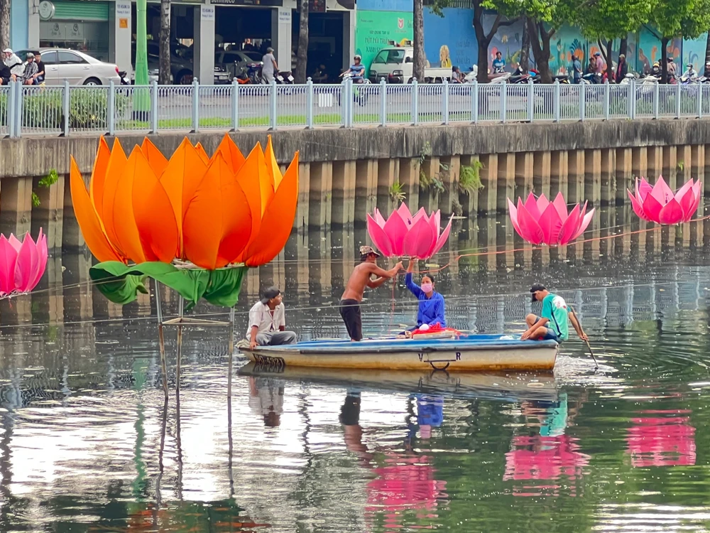 Công nhân đang ráo riết hoàn thành các hạng mục để chuẩn bị cho lễ rước hoa đăng tại khu vực lòng kênh Nghiêu Lộc – Thị Nghè. Ảnh: QUỐC HƯƠNG.