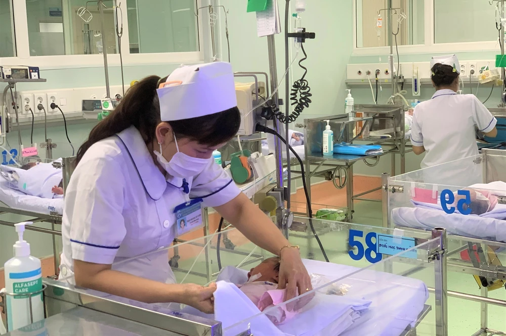 Nhân viên y tế chăm sóc trẻ sơ sinh tại khoa Sơ sinh ở khối nhà mới. Ảnh: THẢO PHƯƠNG