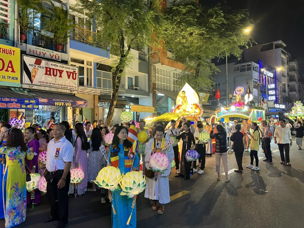 Đông đảo phật tử góp mặt trong đoàn rước kiệu, mỗi người phụ trách một công việc như cầm đèn lông, giương cờ phật, niệm chú… Ảnh: QUỐC HƯƠNG