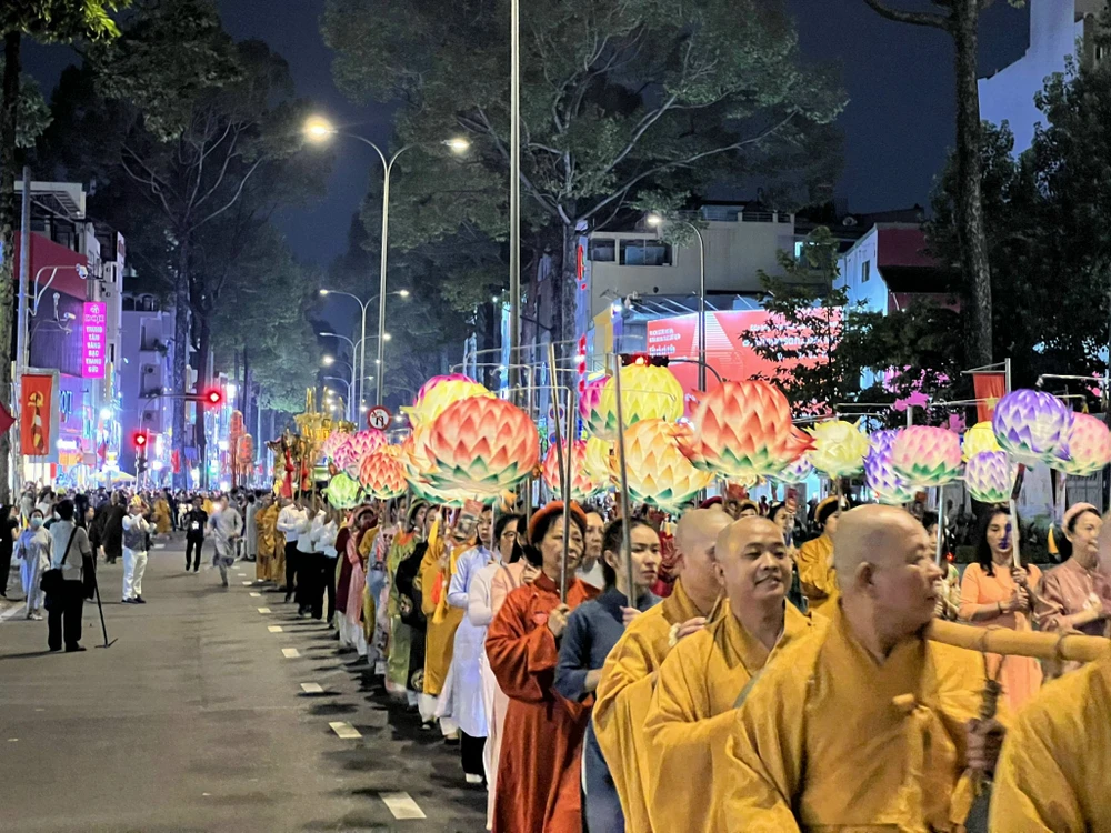 Đoàn rước cầm cờ ngũ sắc trong Phật giáo tiếp tục di chuyển đến bùng binh Lý Thái Tổ (quận 10). Ảnh: QUỐC HƯƠNG