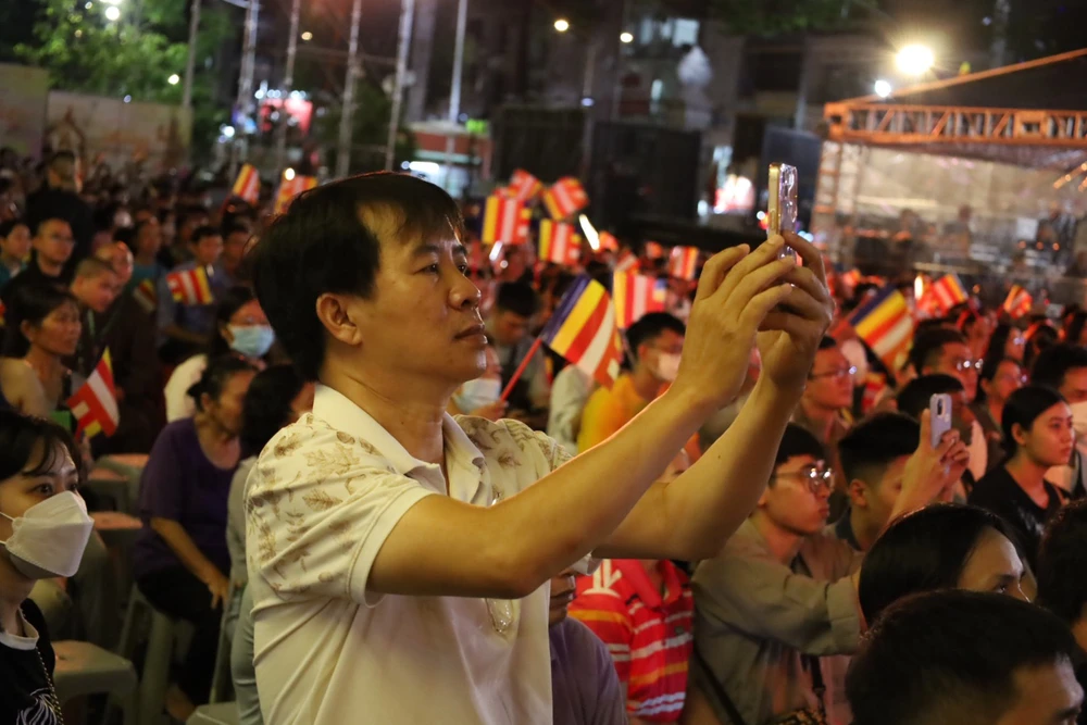 Một số công chúng, phật tử dùng điện thoại ghi lại hình ảnh chương trình. Ảnh: QUỐC HƯƠNG